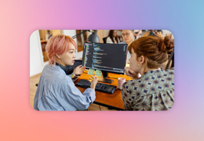 A group of people sitting at a desk looking at a computer screen