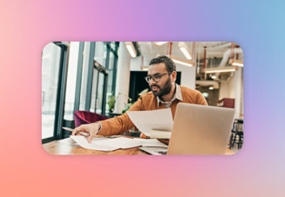 A man sitting at a table with papers and a laptop