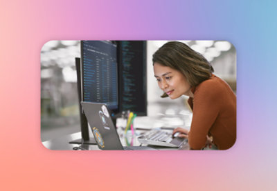 A woman with brown hair working on a laptop.
