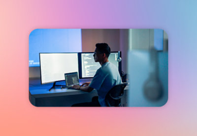 A man sitting at a desk with two computer screens.