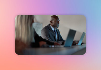 A man in a suit and tie looking at a laptop.