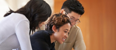 Um grupo de pessoas olhando para a tela de um computador.