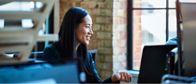 Eine Frau, die auf einen Laptopbildschirm schaut.