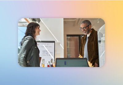 A man and woman standing in front of a computer