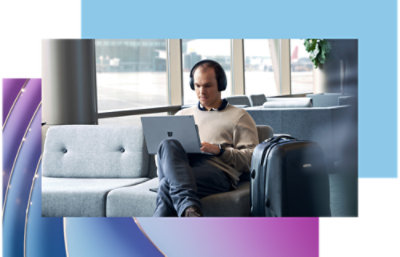 Osoba, která sedí na pohovce a používá přenosný počítač.