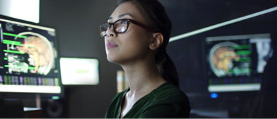 A woman wearing glasses looking up.