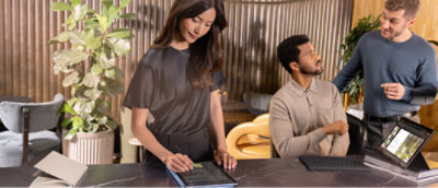 A woman in a black shirt standing at a table and two men's looking each other.