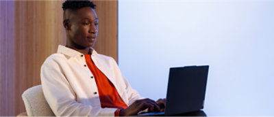 En mand iført en hvid skjorte bruger en bærbar computer.