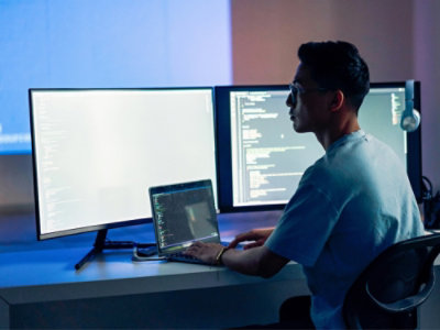 A man sitting at a desk using a laptop.