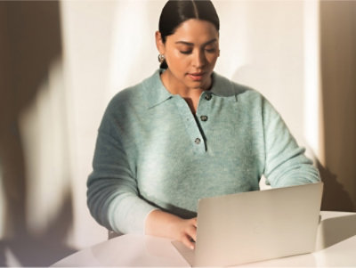 A woman sitting at a desk using a laptop.