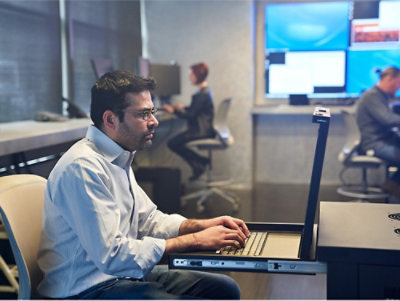 A man sitting at a desk using a laptop.