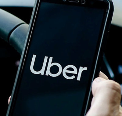 Uber のロゴが表示されている携帯電話を持っている人。