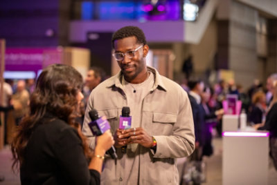 A man holding a microphone and talking to a woman.