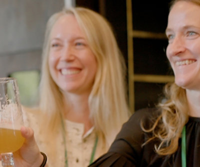 En gruppe kvinner som smiler og holder glass med øl.