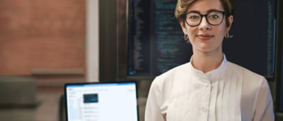 En kvinne med briller som smiler.