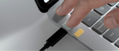 Uma mulher em uma cadeira de rodas conversando com um homem em uma mesa com um notebook.