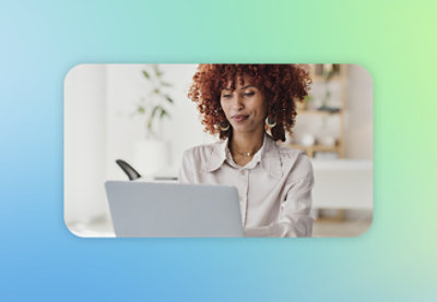 A woman with curly red hair using a laptop