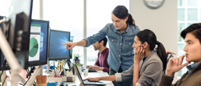 A woman pointing at a computer screen.