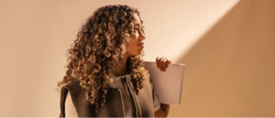 Image 63: A woman with curly hair holding a white paper.