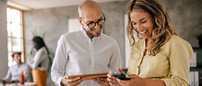A man and woman looking at a tablet.