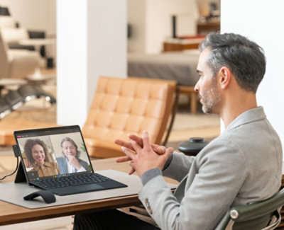 一位男士正在笔记本电脑上与一位女士交谈。