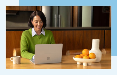 Uma mulher a sorrir e a trabalhar num portátil