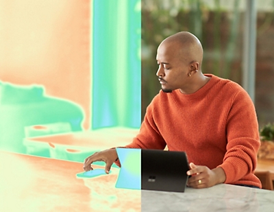 A man sitting at a table using a laptop.