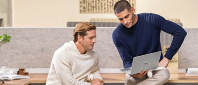 A man sitting on the floor using a laptop.