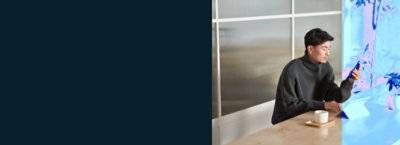 A man sitting at a table looking at a screen.