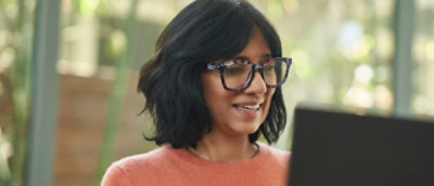 a woman wearing glasses and smiling