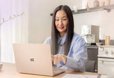 Donna che sorride e indica un portatile.