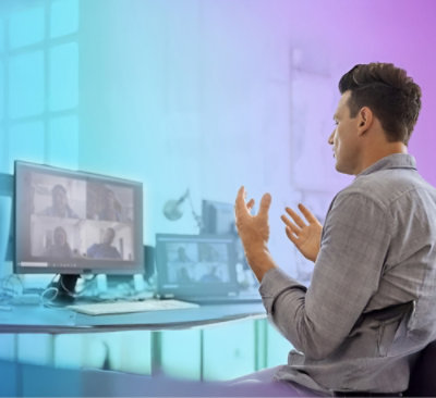 A man in a gray shirt talking to a group of people.