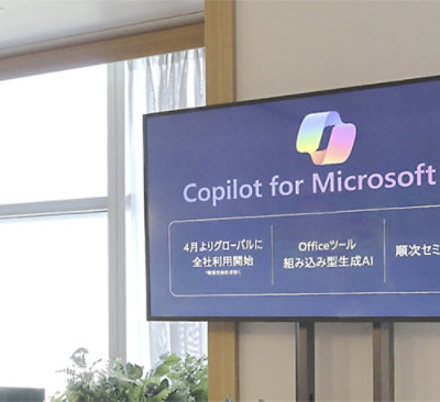 A colorful logo on a black background with text in Japanese and English.