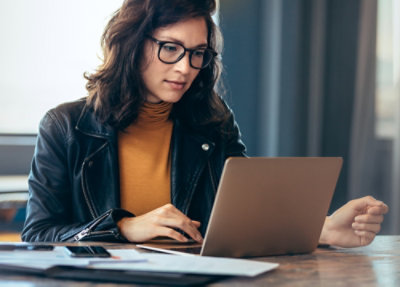 A person sitting at a desk using a laptop.