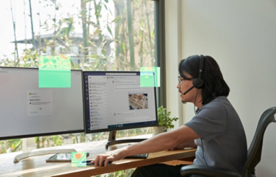 A person wearing headphones and using a computer at a desk.