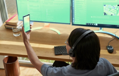 A person wearing headphones and holding a phone.