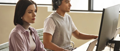 A man and woman sitting at a desk.