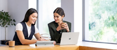 A group of women looking at a laptop on a table indoors.