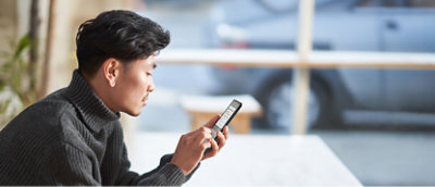 Een man die naar zijn telefoon kijkt.