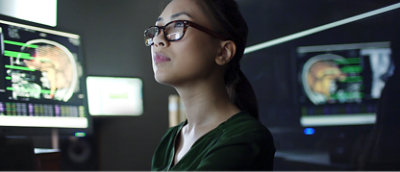 A woman wearing glasses looking up.