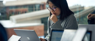 A woman with glasses and a hand on her chin.