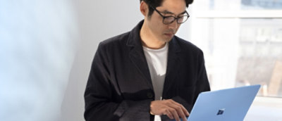 A man in a black jacket using a laptop.