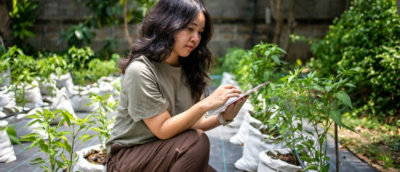 Donna con i capelli lunghi inginocchiata con in mano un foglio di carta.