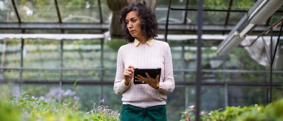 Una donna con i capelli scuri che tiene in mano un tablet.