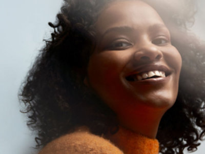 En kvinde med kort hår, der smiler