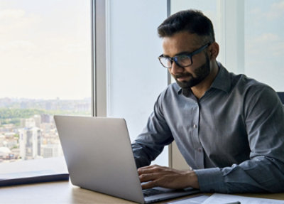 A man sitting on a couch using a laptop.