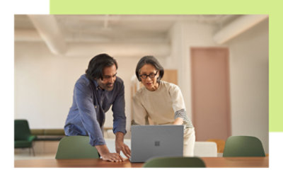 Two people standing and discussing something on a laptop