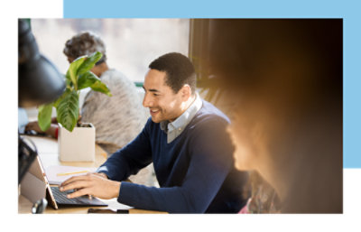 A man sitting in a chair using a laptop.