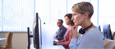 Three people are seated at a table in an office setting