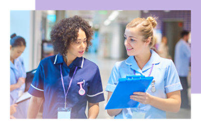 A group of people wearing scrubs talking together indoors.